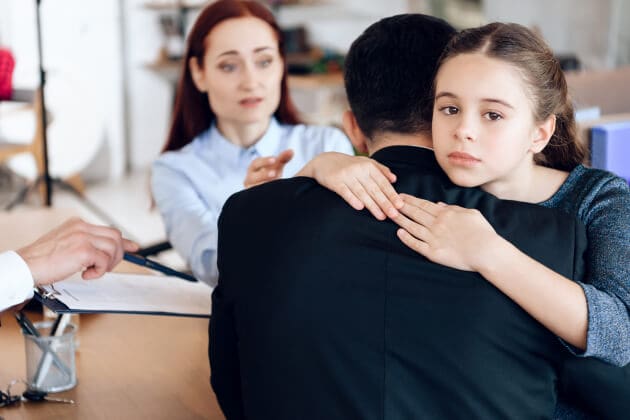 Sad girl hugging father during family mediation