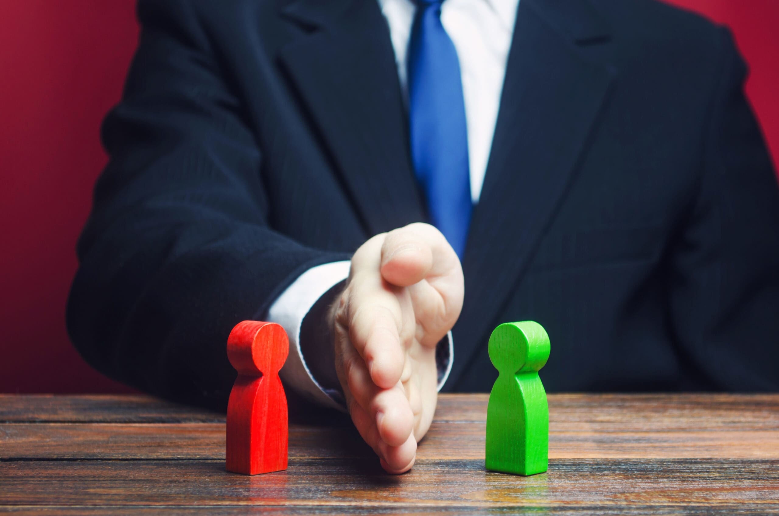 A man in a suit and tie shakes hands with a green-skinned figure, symbolizing a unique partnership or agreement.