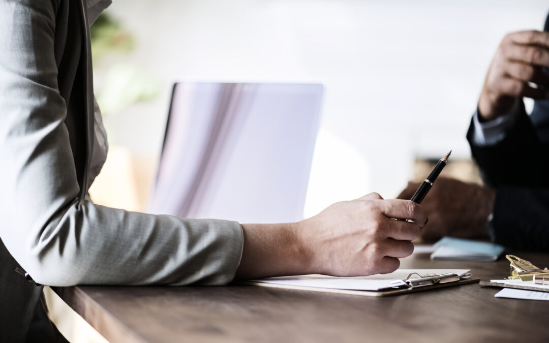Two legal professionals seated at a table, engaged in an arbitration sydney meeting with a pen on paper.